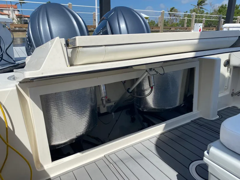 Slide: The Image of 2022 Cobia 301 Center Console boat with open storage compartment and dual engines. - 32