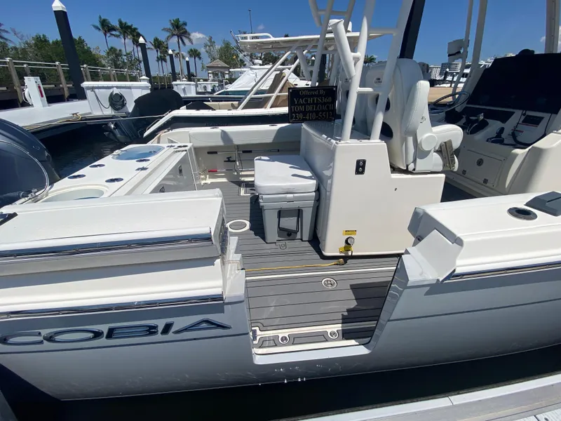 Slide: The Image of 2022 Cobia 301 Center Console boat docked, featuring spacious seating and modern controls. - 4
