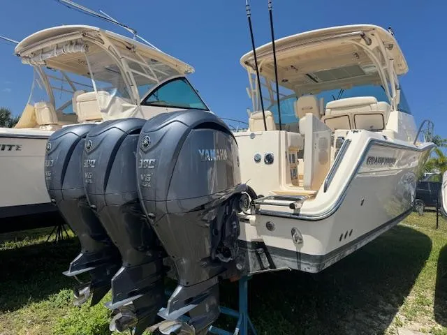 The Image of 2022 Grady-White Express 370 boat with triple Yamaha engines, docked outdoors. - 1