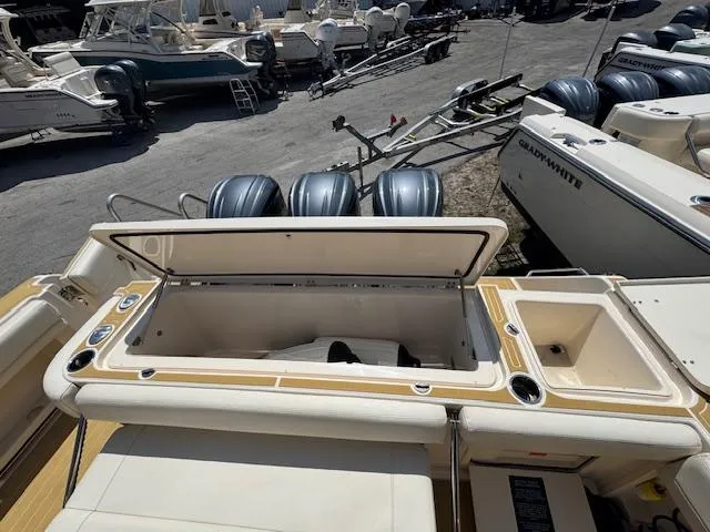 Slide: The Image of 2022 Grady-White Express 370 boat with open storage compartment and multiple outboard engines. - 12