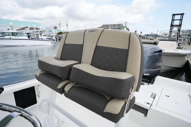 Slide: The Image of 2021 Tidewater 2210 Carolina Bay boat seats, beige and black, docked in marina. - 19