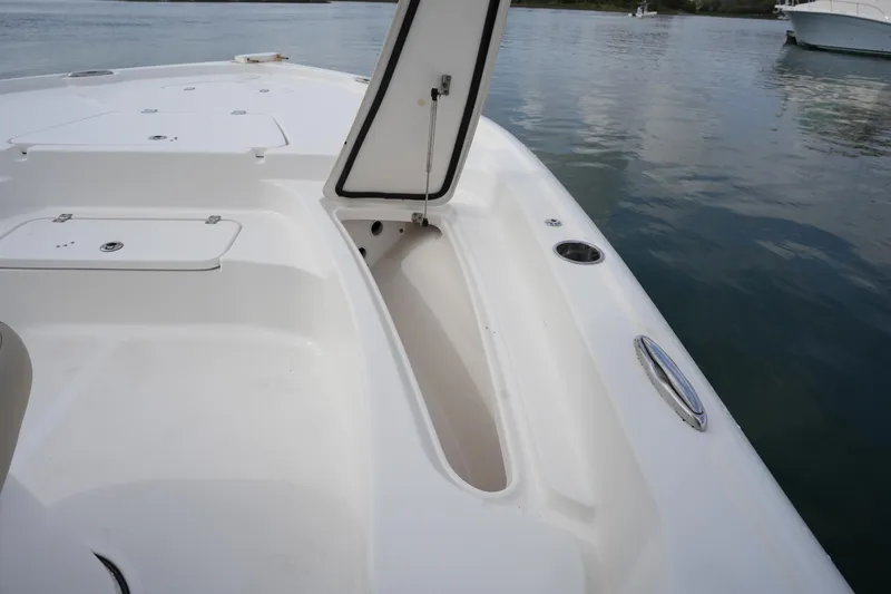 Slide: The Image of 2021 Tidewater 2210 Carolina Bay boat with open storage compartment on calm water. - 34