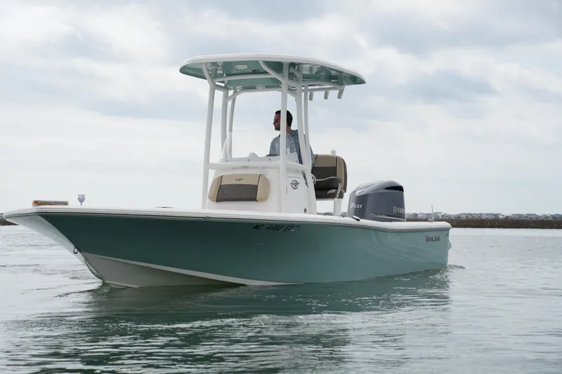 Slide: The Image of 2021 Tidewater 2210 Carolina Bay boat cruising on calm water under cloudy skies. - 7