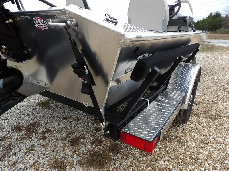 Slide: The Image of 2025 Blazer 1752 SC boat on trailer, rear view, parked on gravel. - 34