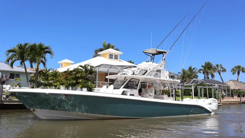 Slide: The Image of 2019 Everglades 435 Center Console boat docked near tropical waterfront home. - 0