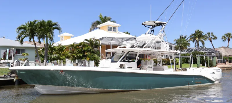 Slide: The Image of 2019 Everglades 435 Center Console boat docked near tropical waterfront home. - 1