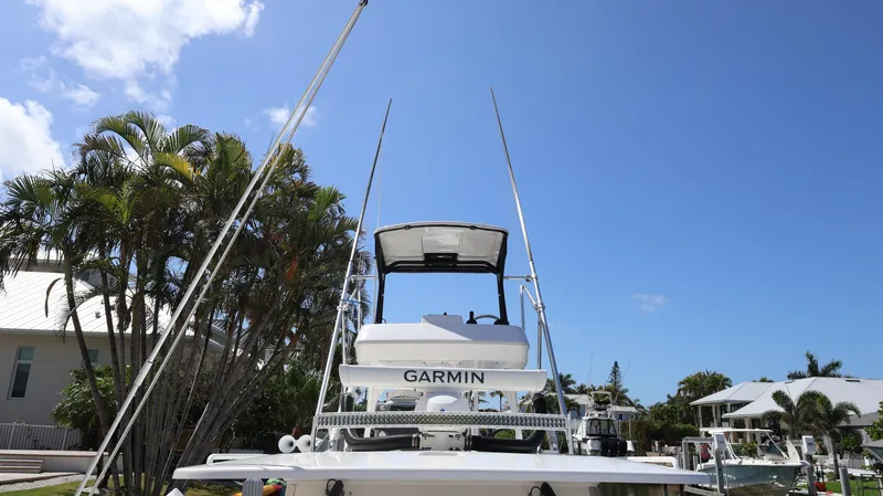 Slide: The Image of 2019 Everglades 435 Center Console boat with Garmin equipment, docked under a clear blue sky. - 10