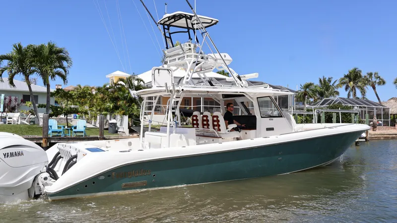 Slide: The Image of 2019 Everglades 435 Center Console boat on water, featuring Yamaha engines, tropical background. - 2