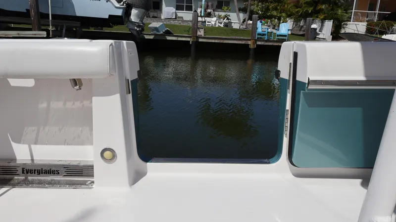 Slide: The Image of 2019 Everglades 435 Center Console boat, rear view, docked by a calm waterfront. - 20