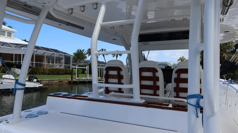 Slide: The Image of 2019 Everglades 435 Center Console boat interior with seating and helm, docked by waterfront homes. - 33