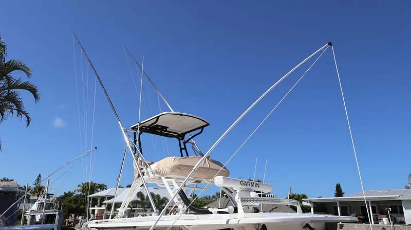 Slide: The Image of 2019 Everglades 435 Center Console boat docked under clear blue sky. - 4
