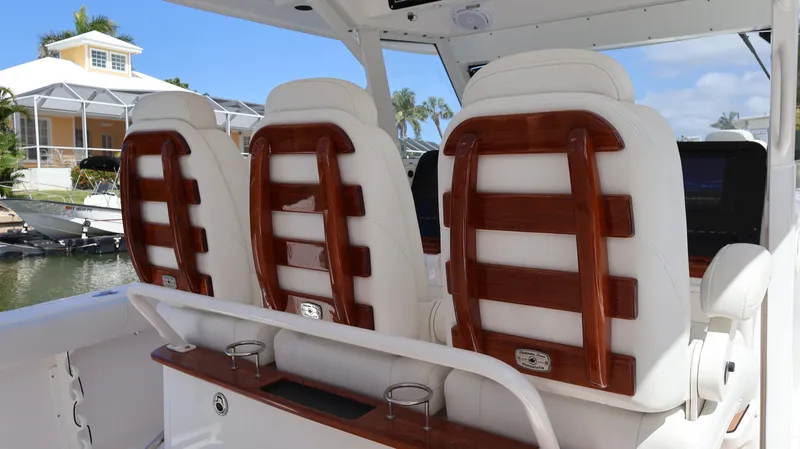 Slide: The Image of 2019 Everglades 435 Center Console boat with luxurious white and wood-accented seating. - 41
