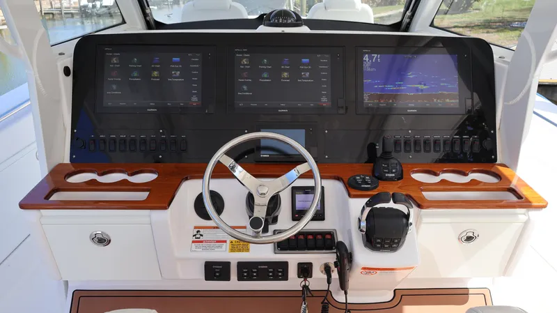 Slide: The Image of 2019 Everglades 435 Center Console boat dashboard with advanced navigation displays and controls. - 44
