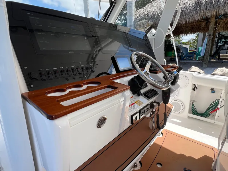 Slide: The Image of 2019 Everglades 435 Center Console boat dashboard with steering wheel and control panel. - 49