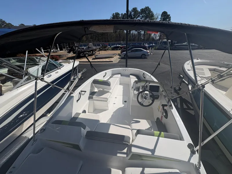 Slide: The Image of 2024 Tahoe T16 boat with canopy, parked in a lot, showcasing interior seating and steering. - 6