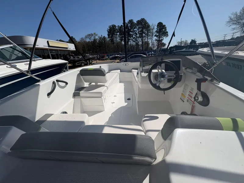 Slide: The Image of 2024 Tahoe T16 boat interior with steering wheel and seating, parked outdoors. - 8