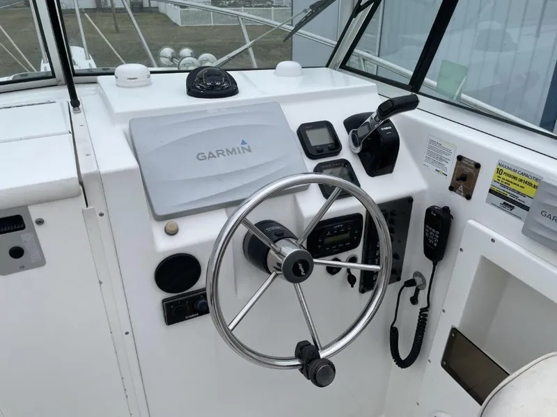Slide: The Image of 2014 Parker 2310 Walkaround boat helm with Garmin navigation system and steering wheel. - 11