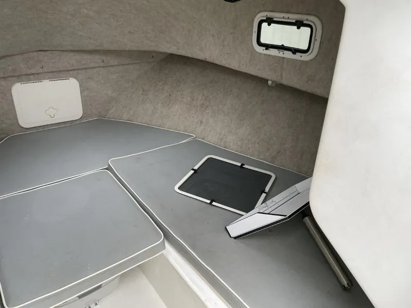 Slide: The Image of 2014 Parker 2310 Walkaround cabin interior with gray cushions and small windows. - 13