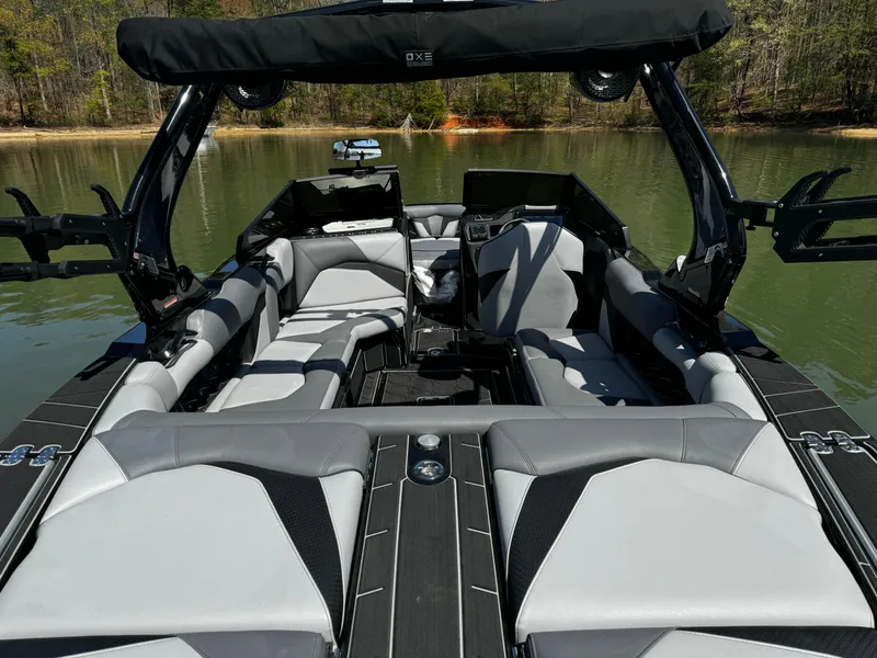 Slide: The Image of 2025 Centurion Fe23 boat interior with sleek gray seating on a calm lake. - 10