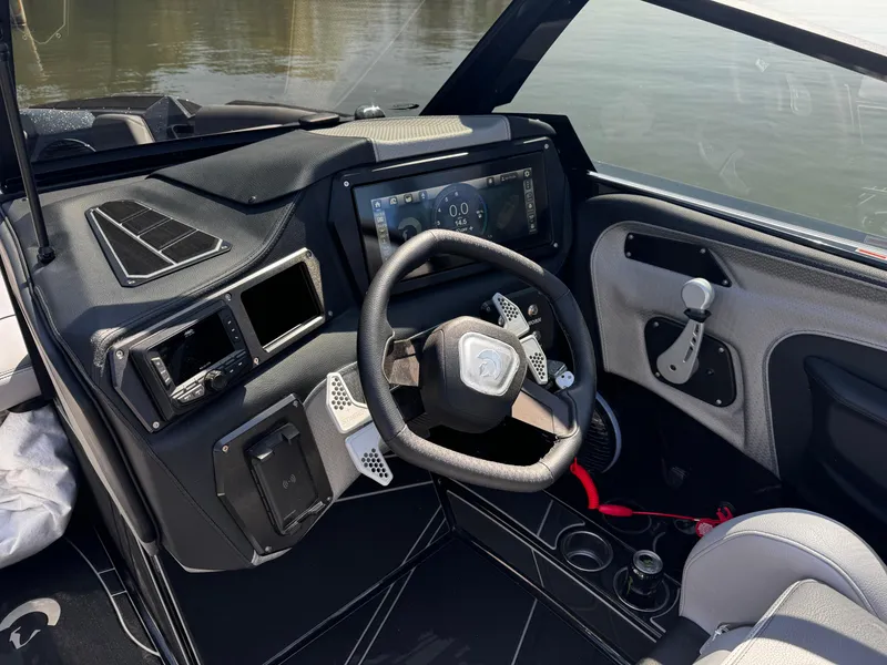 Slide: The Image of 2025 Centurion Fe23 boat dashboard with steering wheel, touchscreen display, and modern controls. - 13