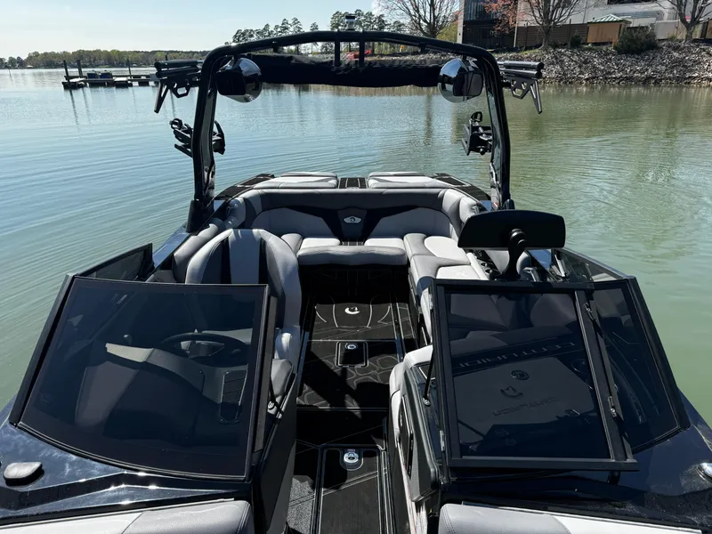 Slide: The Image of 2025 Centurion Fe23 boat interior on calm lake, featuring sleek design and comfortable seating. - 15