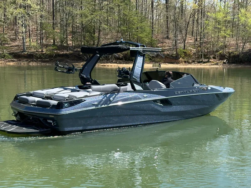 Slide: The Image of 2025 Centurion Fe23 boat on a calm lake surrounded by trees. - 3