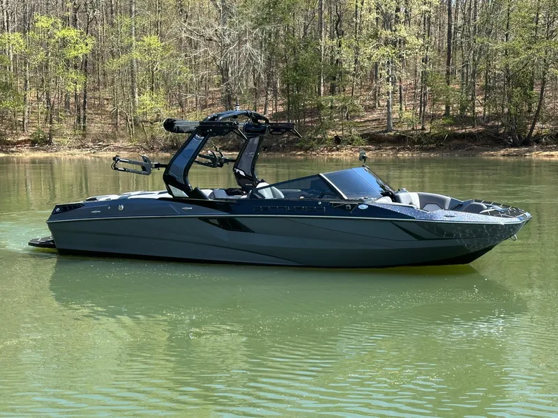 Slide: The Image of 2025 Centurion Fe23 boat on a calm lake with forested background. - 4