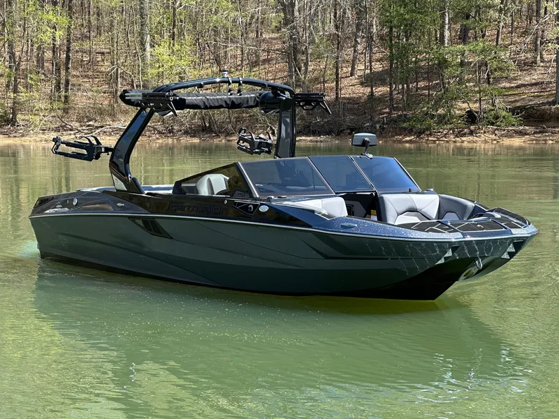 Slide: The Image of 2025 Centurion Fe23 boat on a calm lake surrounded by trees. - 5