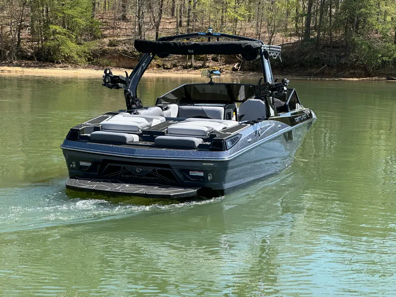 Slide: The Image of 2025 Centurion Fe23 boat cruising on a calm lake surrounded by trees. - 7