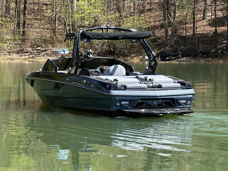 Slide: The Image of 2025 Centurion Fe23 boat on a calm lake surrounded by trees. - 8