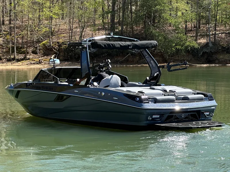 Slide: The Image of 2025 Centurion Fe23 boat on a calm lake with forested background. - 9