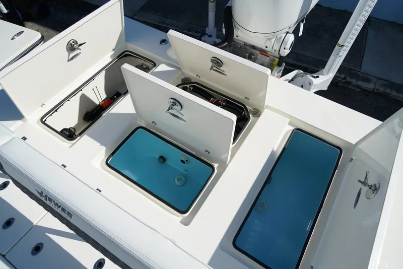 Slide: The Image of 2025 Hewes Redfisher 21 boat storage compartments and livewells, showcasing organized fishing gear space. - 13
