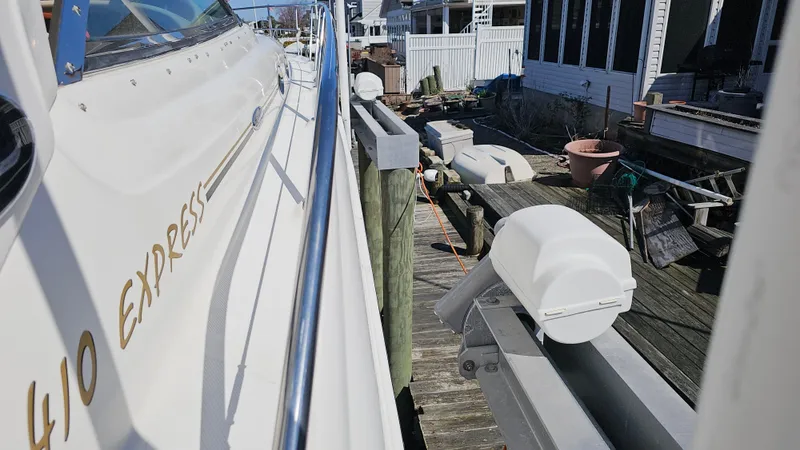 Slide: The Image of 2003 Sea Ray 410 Express Cruiser docked beside a wooden pier. - 16