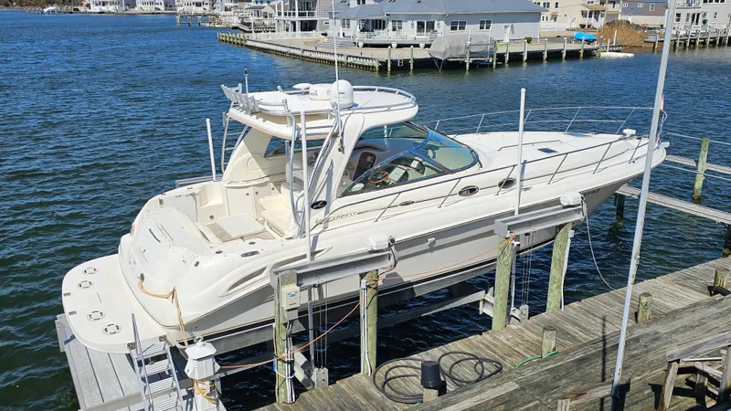 Slide: The Image of 2003 Sea Ray 410 Express Cruiser docked at marina, showcasing sleek design and spacious deck. - 2