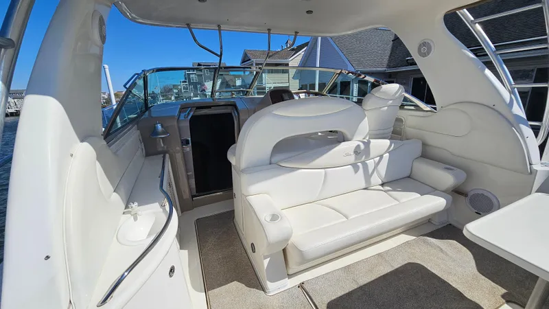 Slide: The Image of 2003 Sea Ray 410 Express Cruiser interior with white seating and helm, docked at marina. - 22