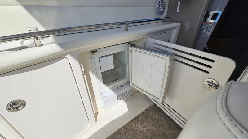 Slide: The Image of 2003 Sea Ray 410 Express Cruiser interior with open mini fridge and storage compartments. - 23