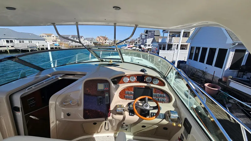 Slide: The Image of 2003 Sea Ray 410 Express Cruiser helm with waterfront view and modern controls. - 29
