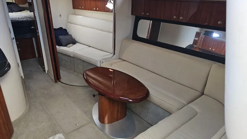 Slide: The Image of 2003 Sea Ray 410 Express Cruiser interior with beige seating and wooden table. - 30