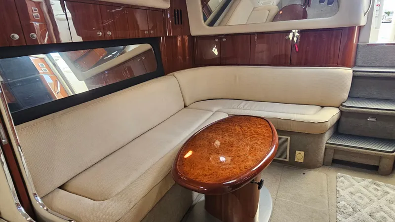 Slide: The Image of Interior of 2003 Sea Ray 410 Express Cruiser with beige seating and wooden table. - 32