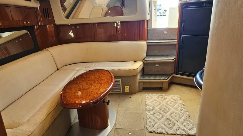 Slide: The Image of Interior of 2003 Sea Ray 410 Express Cruiser with beige seating and wooden table. - 33