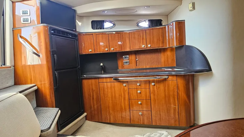 Slide: The Image of 2003 Sea Ray 410 Express Cruiser interior with wood cabinetry and modern kitchen amenities. - 36