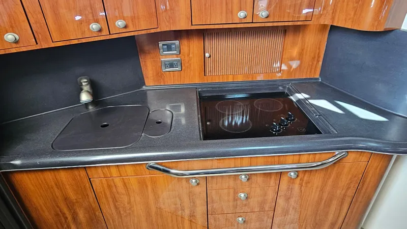 Slide: The Image of 2003 Sea Ray 410 Express Cruiser kitchen with sleek wood cabinetry and modern appliances. - 37
