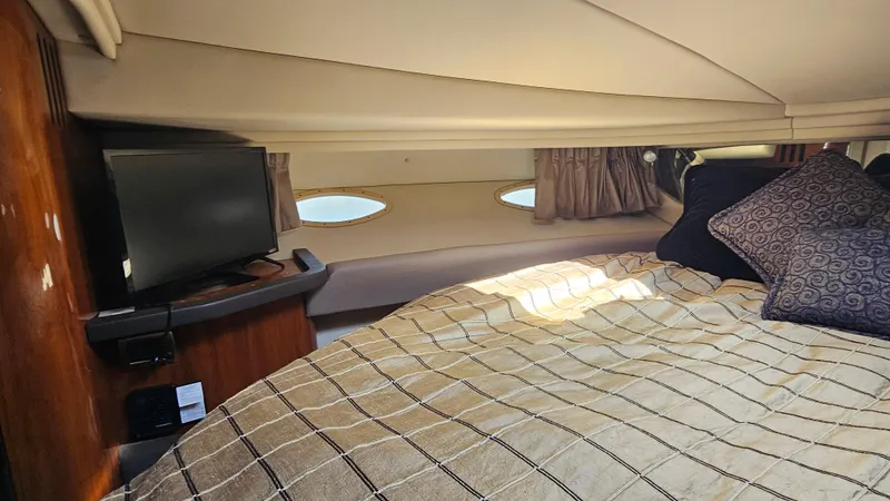 Slide: The Image of Interior of 2003 Sea Ray 410 Express Cruiser with bed, TV, and portholes. - 41