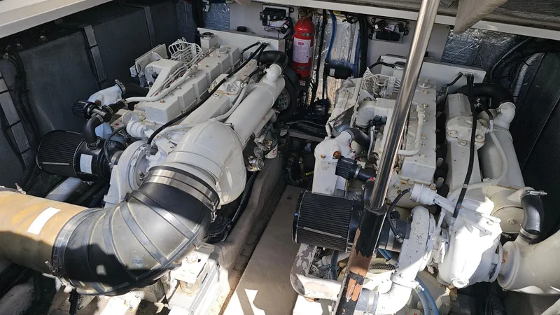 Slide: The Image of Engine room of a 2003 Sea Ray 410 Express Cruiser, showcasing dual engines and mechanical components. - 49