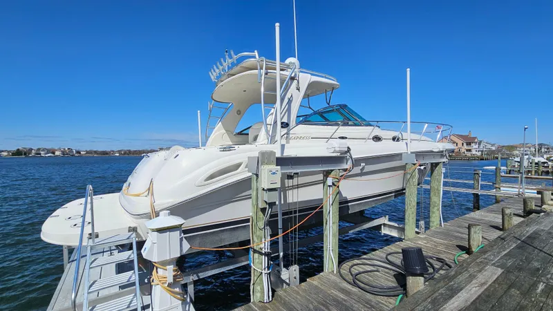 Slide: The Image of 2003 Sea Ray 410 Express Cruiser docked by the water on a sunny day. - 7