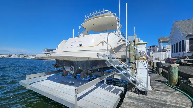 Slide: The Image of 2003 Sea Ray 410 Express Cruiser docked by waterfront homes. - 8
