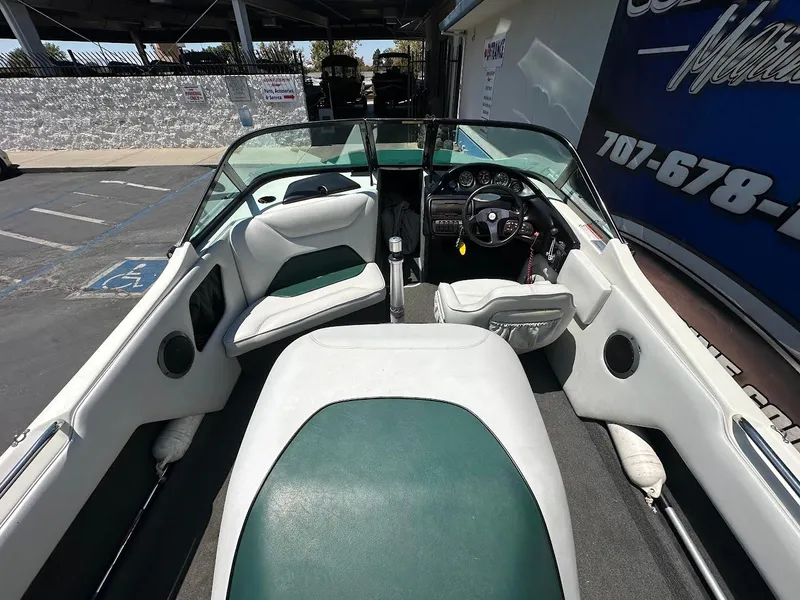 Slide: The Image of 1998 Ski Centurion sport bowrider interior with green and white seating, steering wheel, and dashboard. - 11