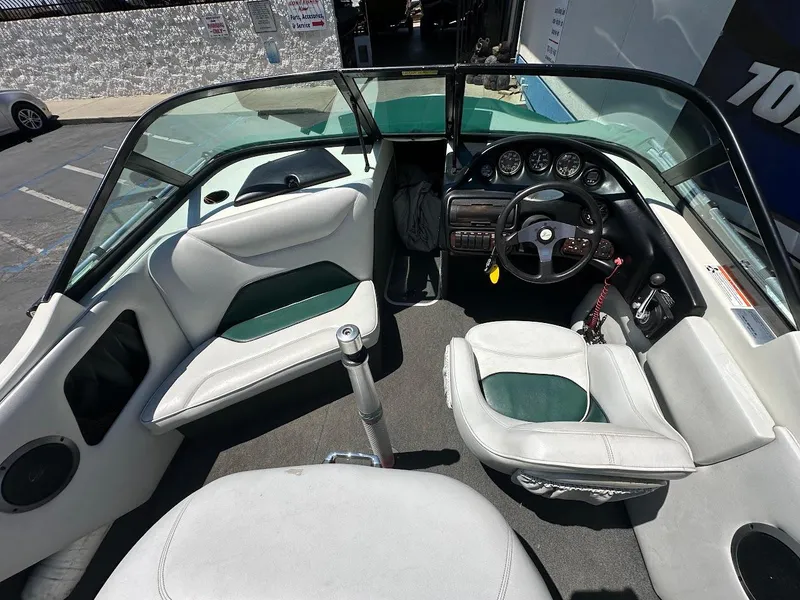 Slide: The Image of 1998 Ski Centurion sport bowrider interior with white and green seating, steering wheel, and dashboard. - 12