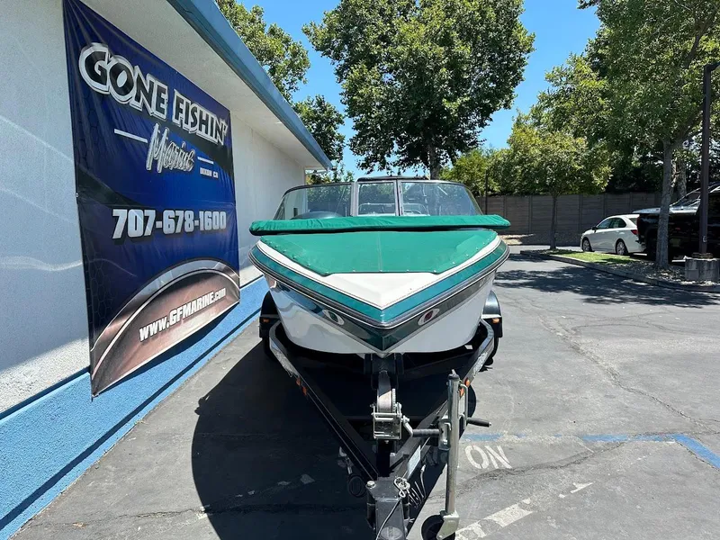 Slide: The Image of 1998 Ski Centurion sport bowrider boat on trailer, parked near a building with a "Gone Fishin'" sign. - 3