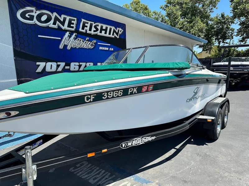 Slide: The Image of 1998 Ski Centurion sport bowrider boat on trailer, parked outside a fishing store. - 5